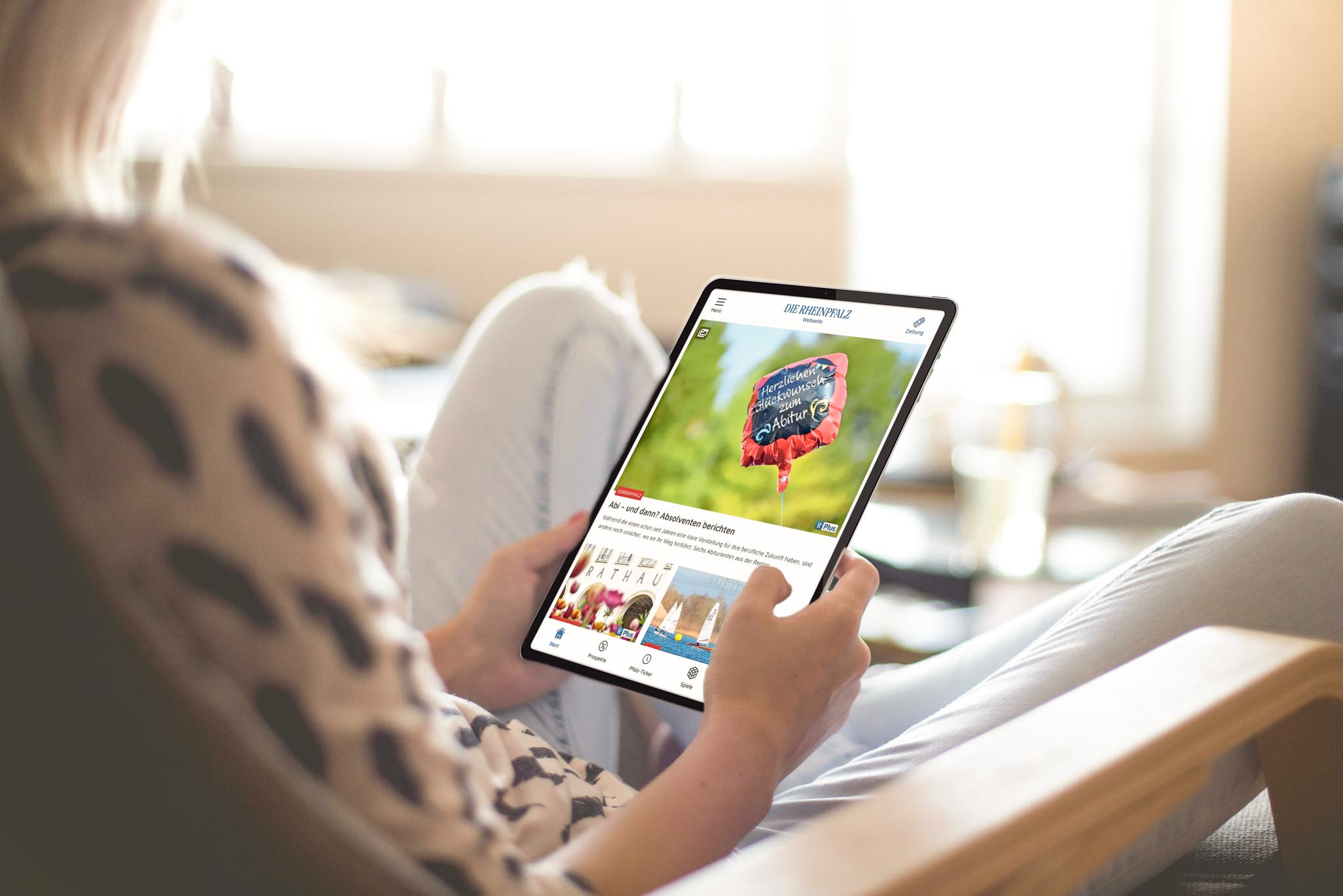 Frau von hinten liest die RHEINPFALZ auf einem Tablet.