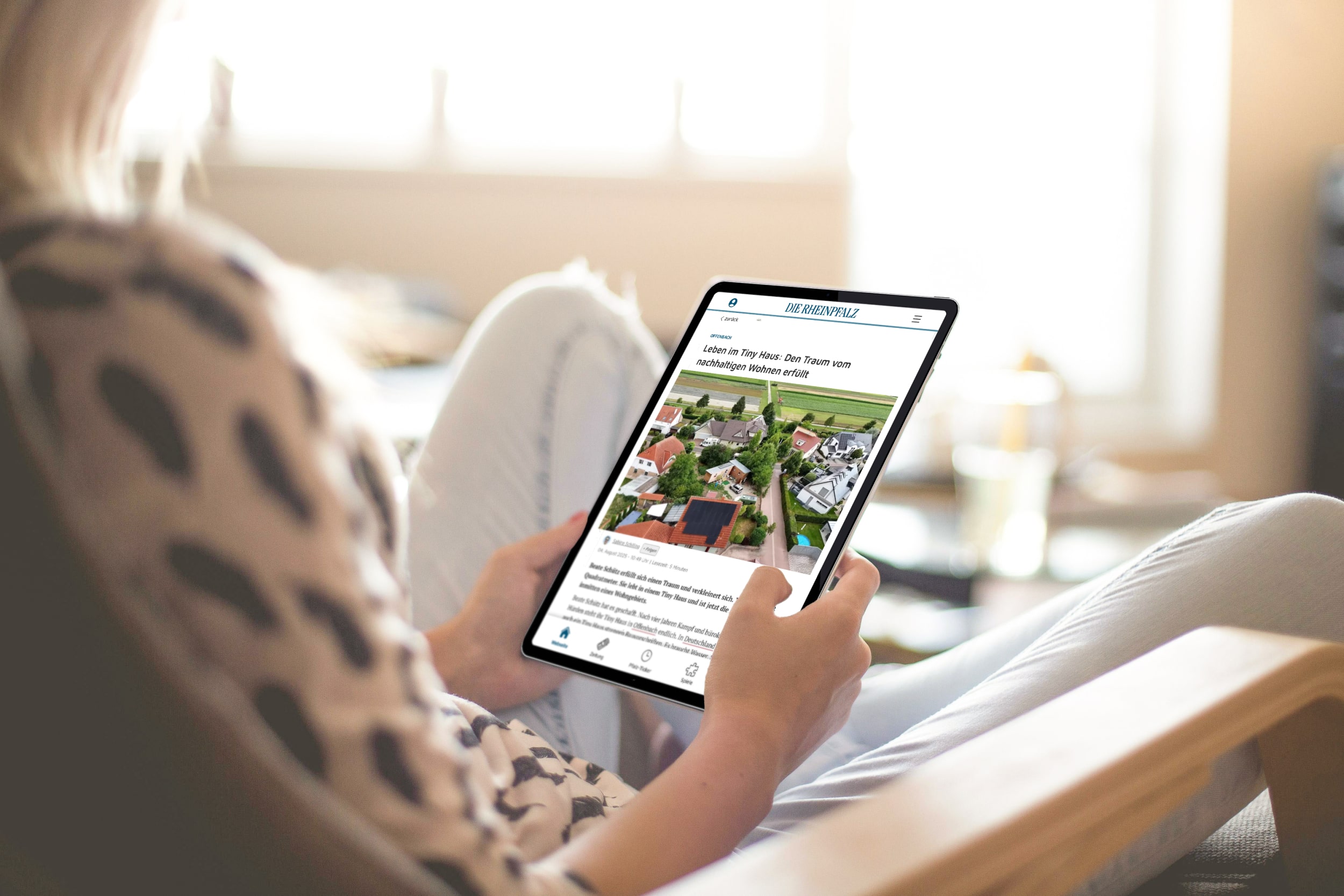 Frau von hinten liest die RHEINPFALZ in der App auf einem Tablet.